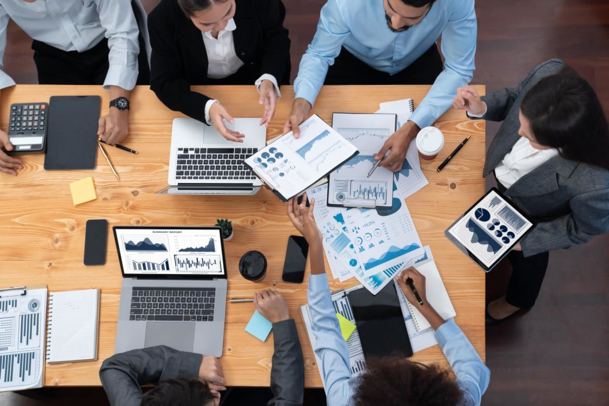 Business people working around big office desk.