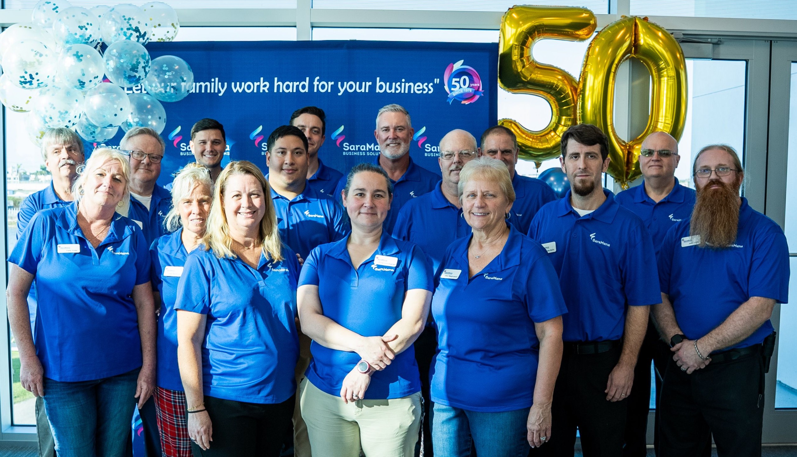 A man in a suit sitting infront of a laptop, holding out his hand with a 3D display of the globe in his hand